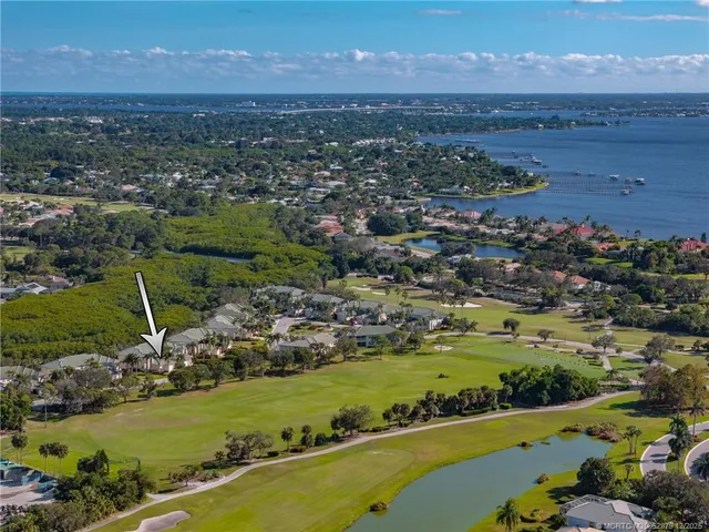 an aerial view of a city with lots of residential buildings ocean and mountain view in back