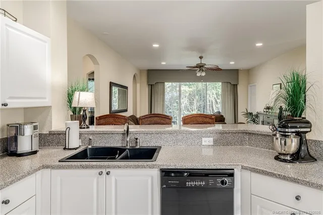 a kitchen with stainless steel appliances granite countertop a sink a stove and a wooden floors