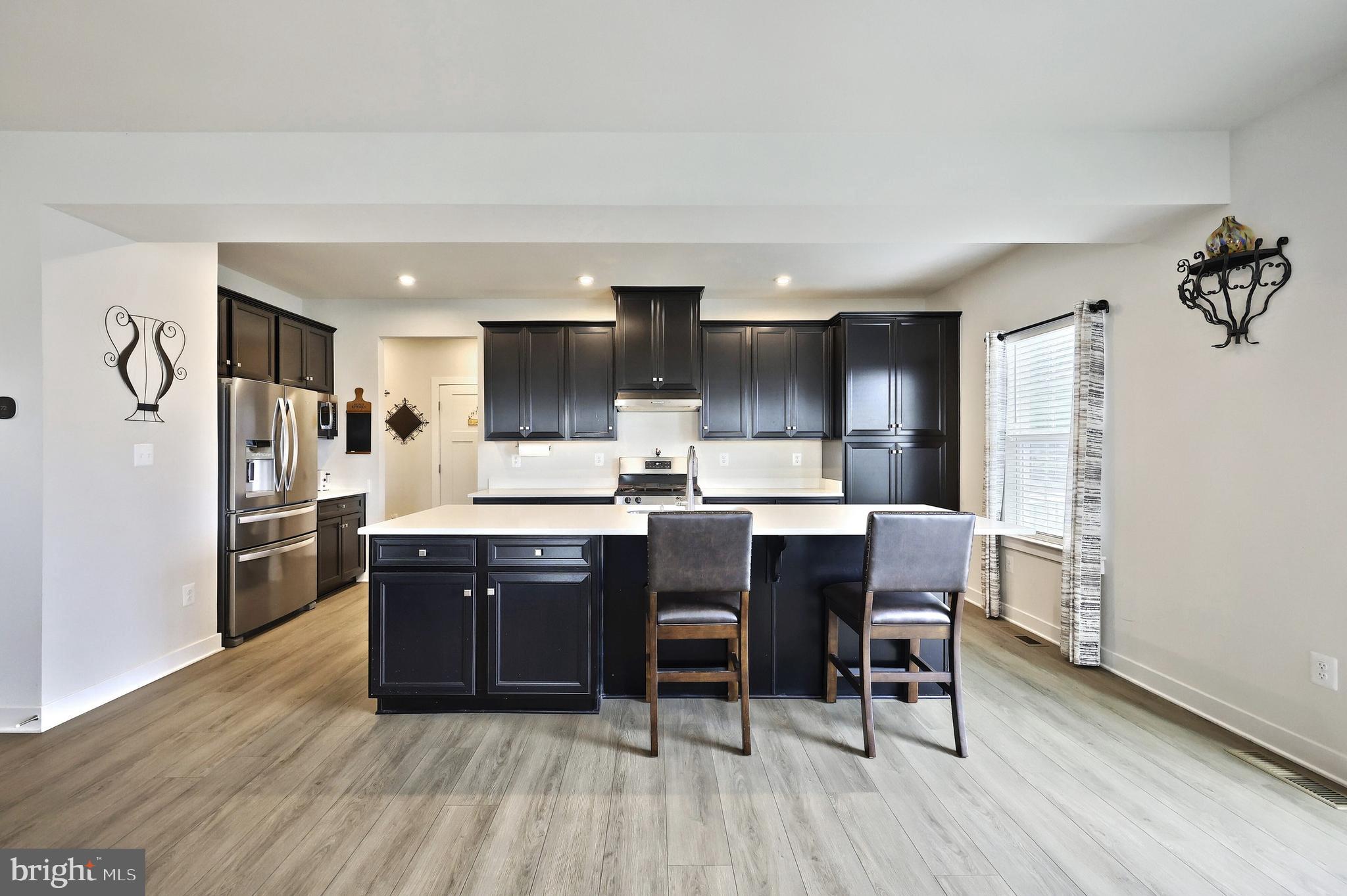 1480 Beck Mill Road Hanover, PA 17331 - Photo 5 of 71 a kitchen with stainless steel appliances granite countertop a refrigerator a sink dishwasher a stove and a dining table with wooden floor