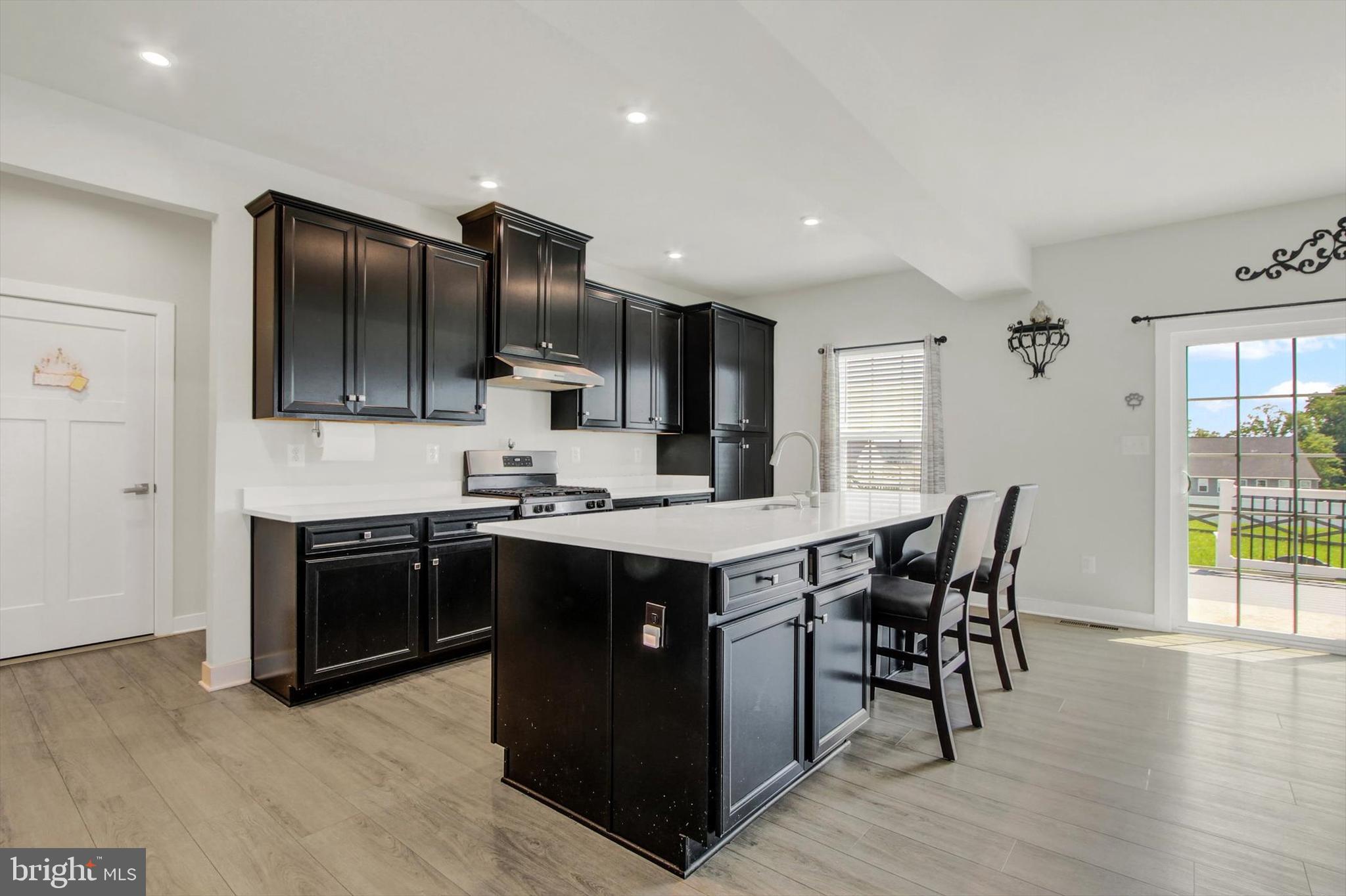 1480 Beck Mill Road Hanover, PA 17331 - Photo 6 of 71 a kitchen with stainless steel appliances kitchen island granite countertop a stove top oven a sink dishwasher a dining table and chairs with wooden floor