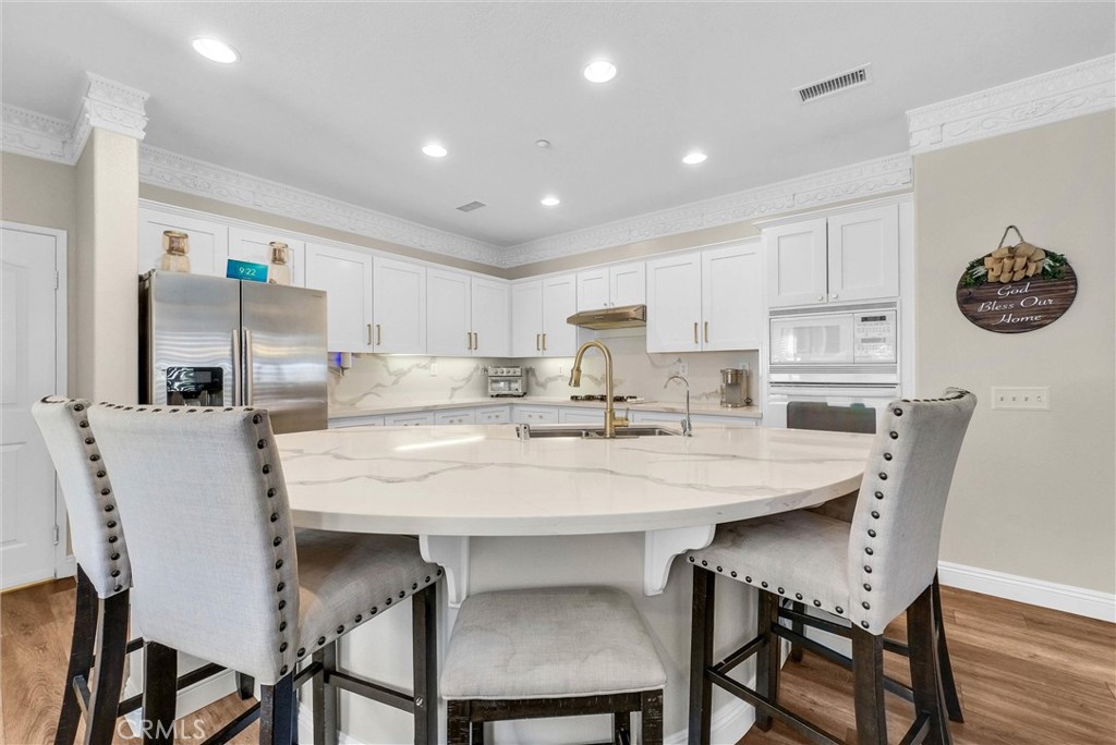 11499 Bridgeway Drive Riverside, CA 92505 - Photo 21 of 65 a kitchen with a dining table chairs and refrigerator
