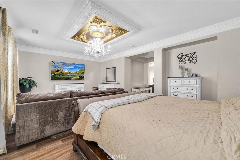 11499 Bridgeway Drive Riverside, CA 92505 - Photo 28 of 65 a spacious bedroom with a bed and a chandelier