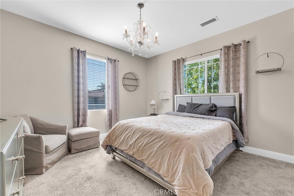 11499 Bridgeway Drive Riverside, CA 92505 - Photo 36 of 65 a spacious bedroom with a bed and a chandelier
