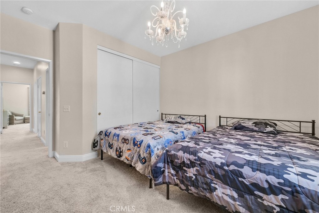 11499 Bridgeway Drive Riverside, CA 92505 - Photo 38 of 65 a bedroom with a bed and a chandelier