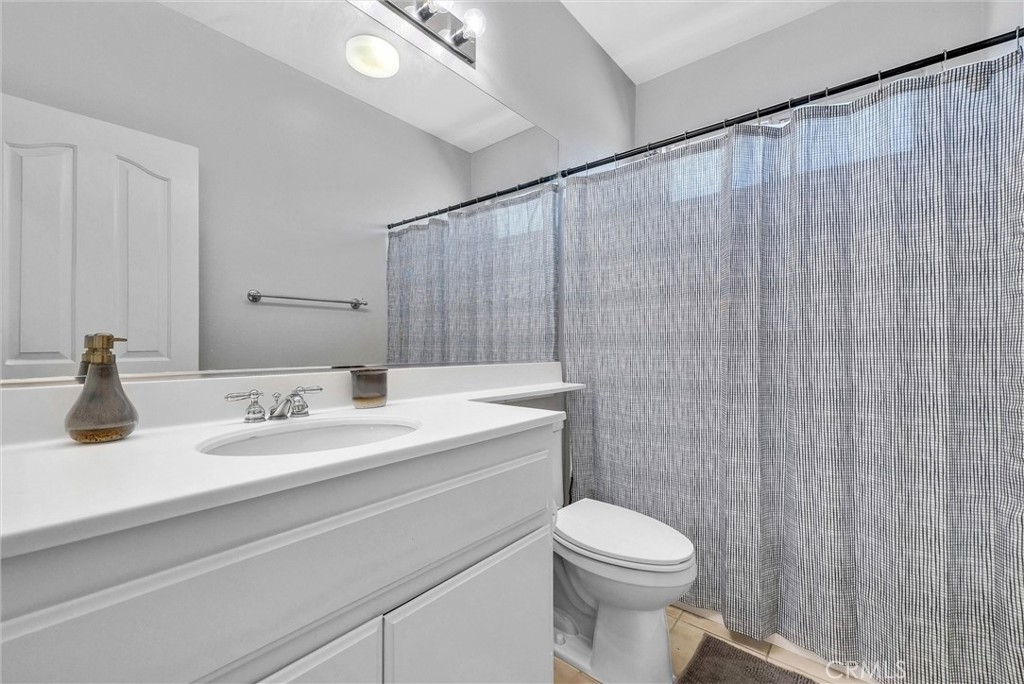 11499 Bridgeway Drive Riverside, CA 92505 - Photo 41 of 65 a bathroom with a sink a toilet and shower curtain