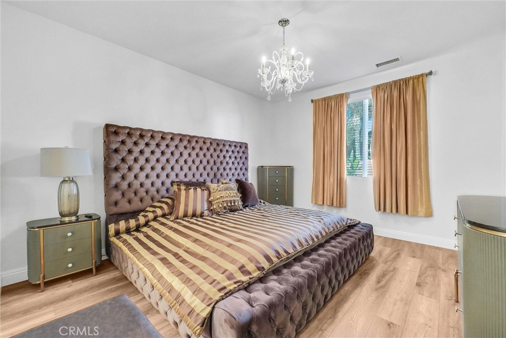 11499 Bridgeway Drive Riverside, CA 92505 - Photo 45 of 65 a bedroom with a large bed and a chandelier