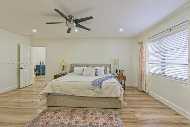 a bedroom with a large bed and a ceiling fan