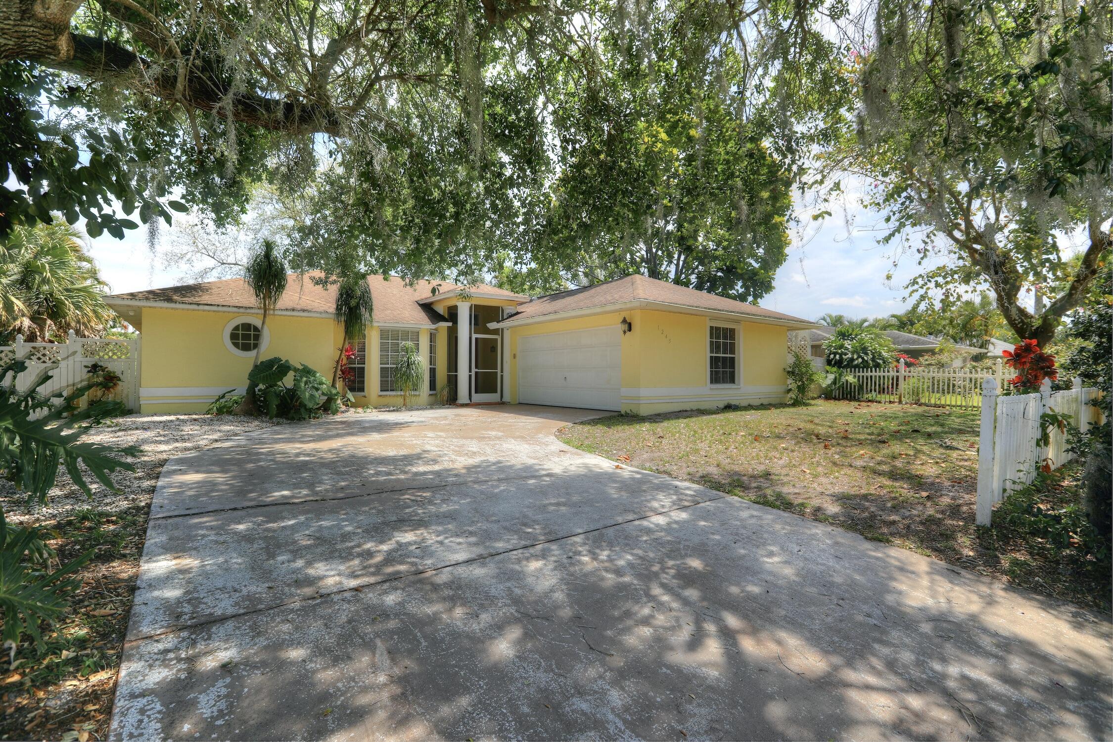 1245 George Street Sebastian, FL 32958 - Photo 1 of 36 a front view of a house with a yard and garage