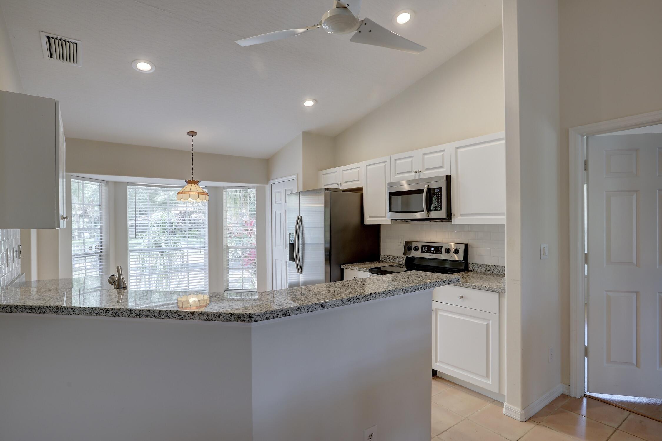 1245 George Street Sebastian, FL 32958 - Photo 22 of 36 a kitchen with granite countertop a sink and stainless steel appliances
