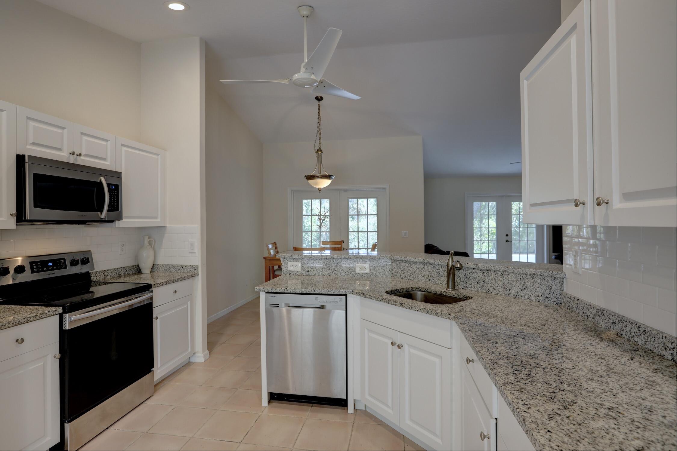 1245 George Street Sebastian, FL 32958 - Photo 24 of 36 a kitchen with granite countertop a sink and stainless steel appliances