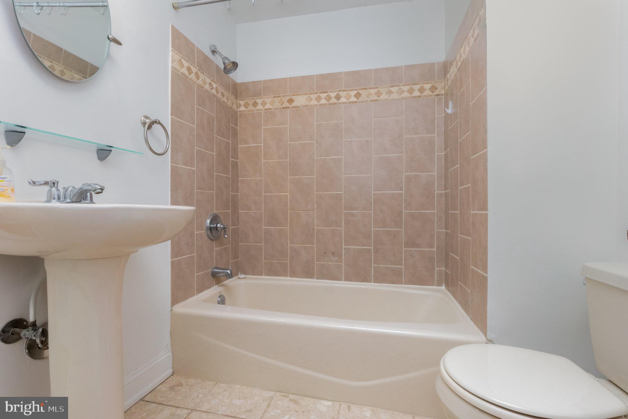 1118 Riverside Avenue Baltimore, MD 21230 - Photo 14 of 28 a bathroom with a bathtub shower sink vanity and toilet