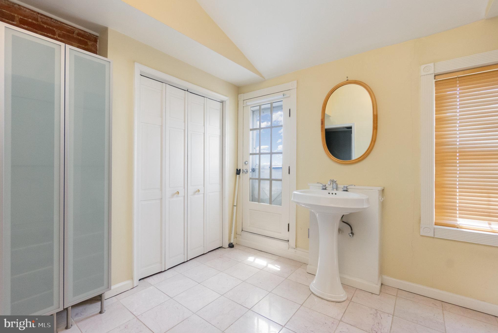 1118 Riverside Avenue Baltimore, MD 21230 - Photo 21 of 28 a spacious bathroom with a sink a mirror and a shower
