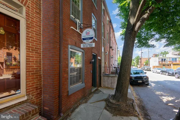 a view of a brick house with a large tree