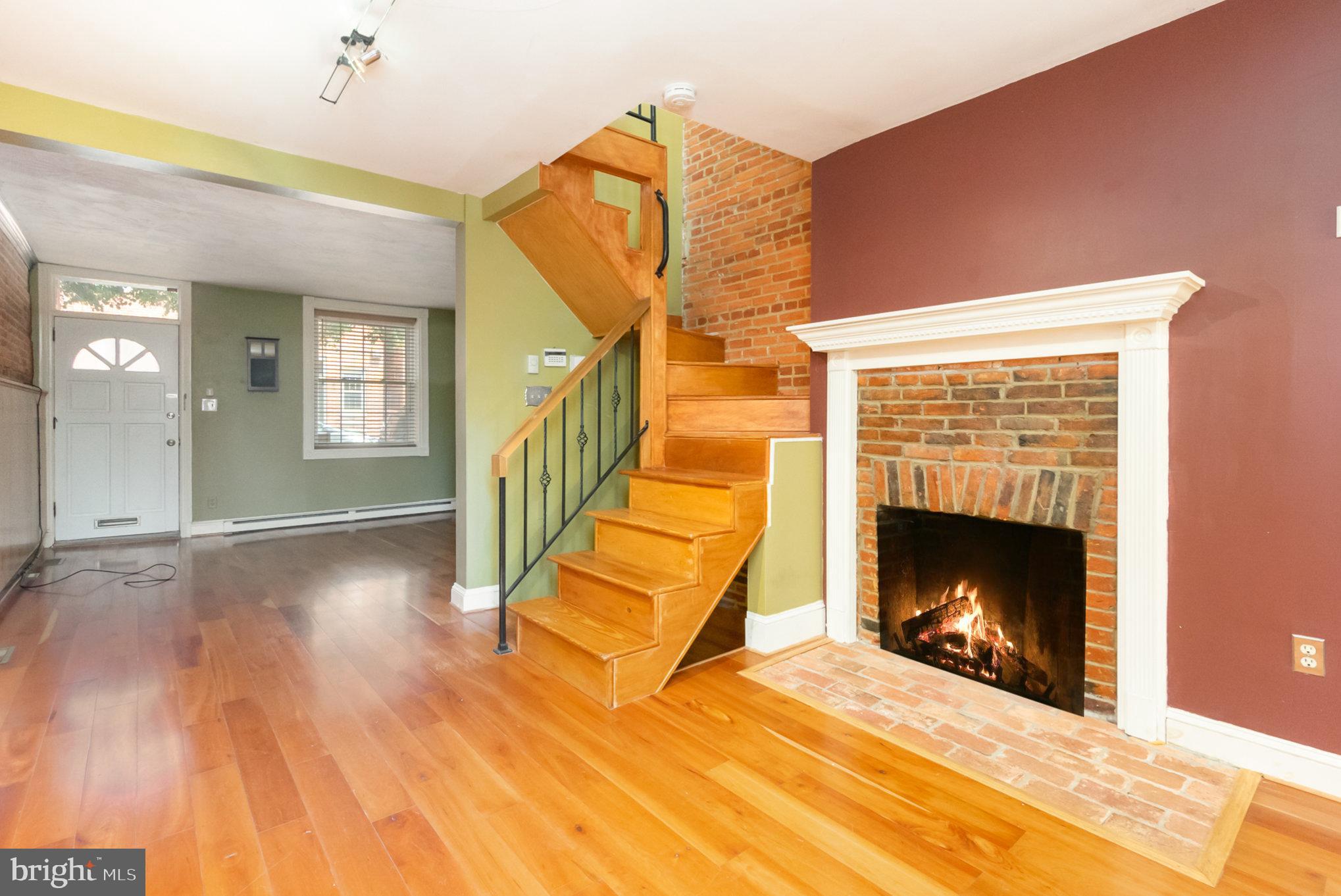 1118 Riverside Avenue Baltimore, MD 21230 - Photo 7 of 28 a view of an empty room with wooden floor fireplace and a window