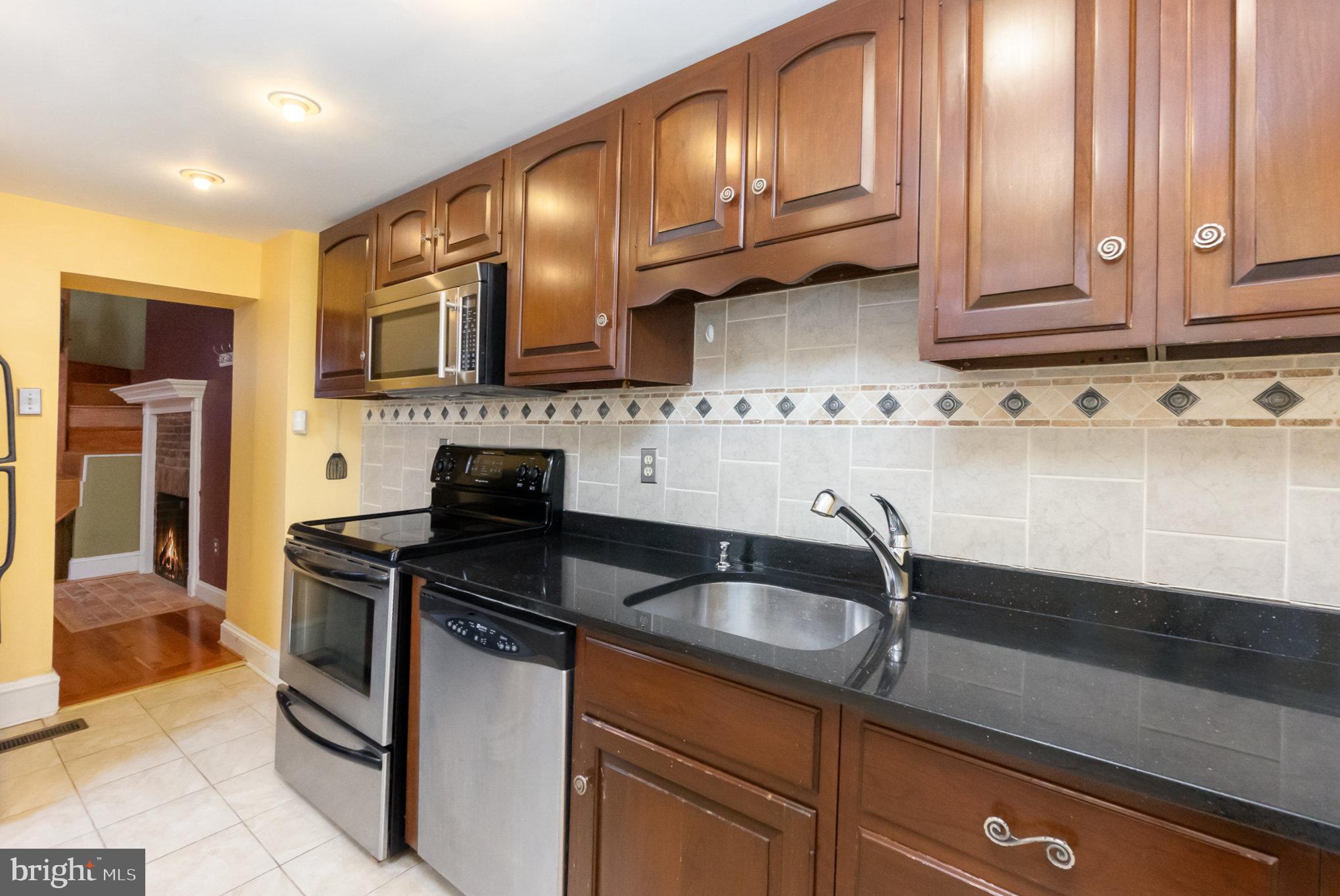 1118 Riverside Avenue Baltimore, MD 21230 - Photo 10 of 28 a kitchen with stainless steel appliances granite countertop a sink stove and cabinets
