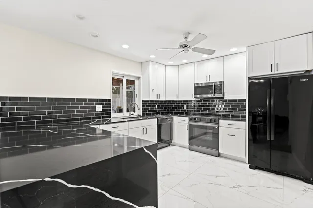 a kitchen with a refrigerator and white cabinets