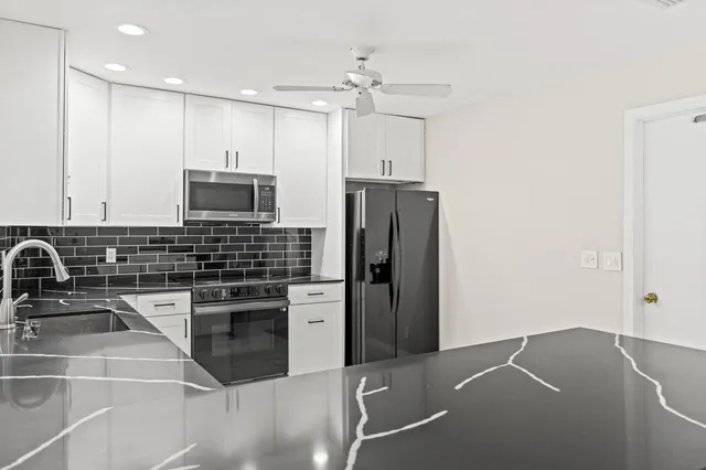 a kitchen with stainless steel appliances a stove a sink a refrigerator and cabinets