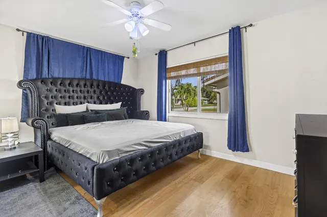 a bed sitting in a spacious bedroom next to a window