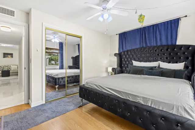 a bedroom with bed and wooden floor