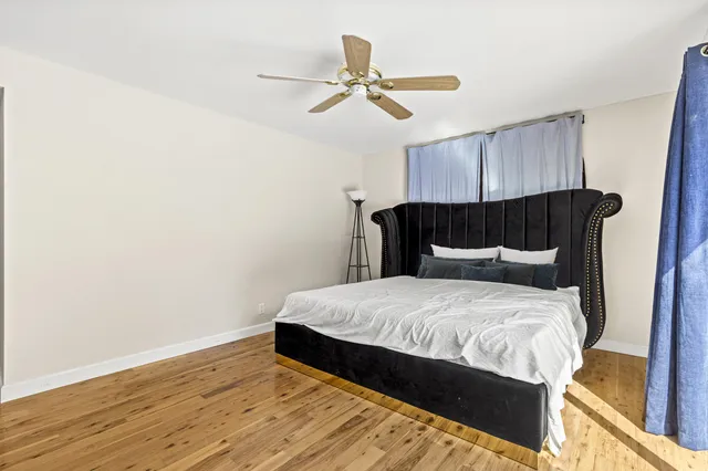 a bedroom with a bed and wooden floor