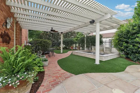 a view of a patio with a table chair and a garden