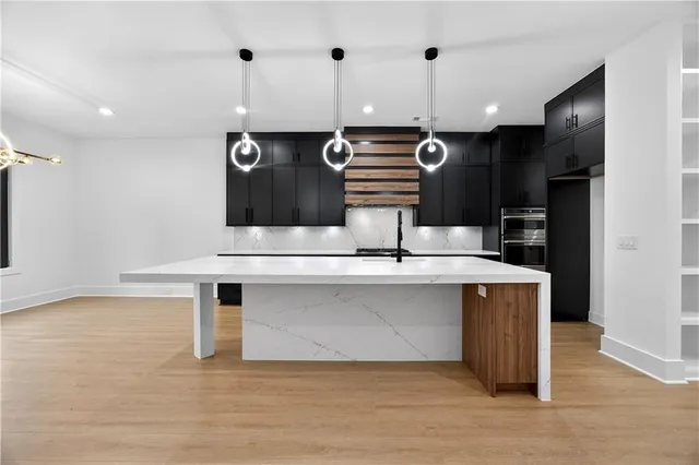 a large white kitchen with a sink and dishwasher a oven with wooden floor
