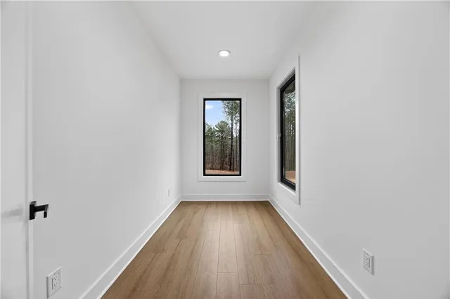 a view of an empty room with wooden floor