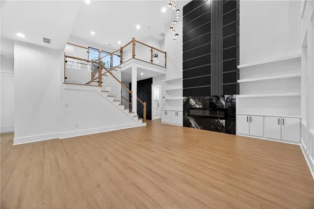 a view of an empty room with wooden floor and a cabinet