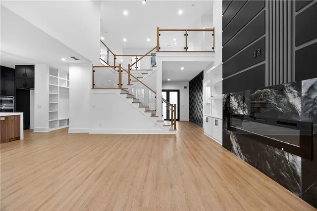 a view of an empty room with a window and wooden floor
