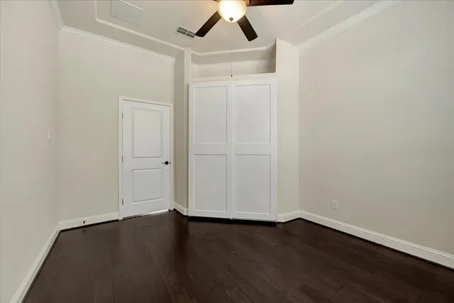 an empty room with a hardwood and ceiling fan