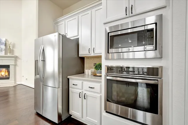 a kitchen with stainless steel appliances white cabinets a stove and a microwave