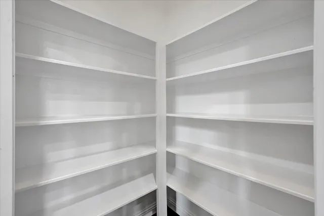 a view of walk in closet with empty racks
