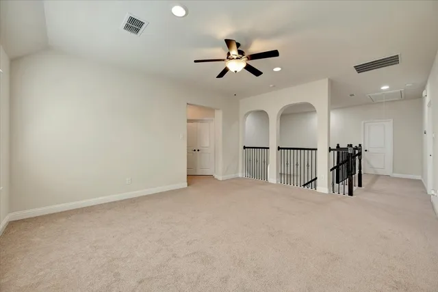 a view of an empty room and a chandelier fan