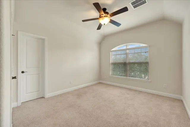 an empty room with a ceiling fan and a window