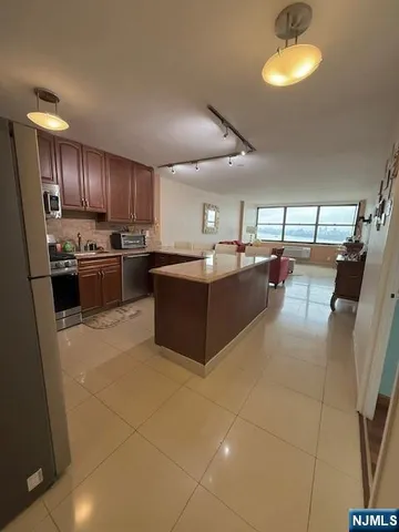a large kitchen with cabinets and stainless steel appliances