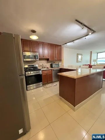 a kitchen with stainless steel appliances granite countertop a stove top oven a sink and cabinets