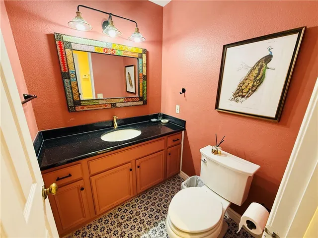 a bathroom with a toilet a sink and mirror