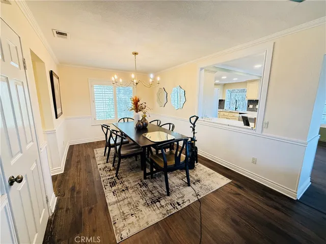 a view of a a dining room with furniture window and wooden floor