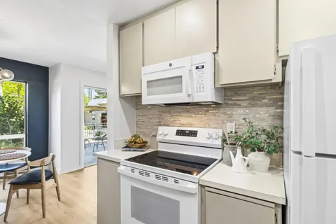 a kitchen with stainless steel appliances white cabinets and a stove top oven
