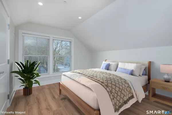 a bedroom with a large bed and a potted plant