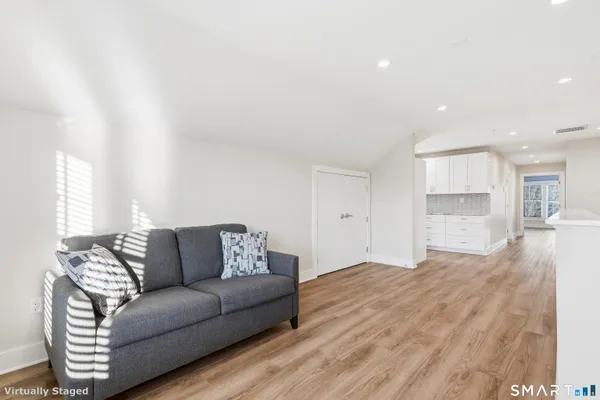 a living room with furniture and a wooden floor