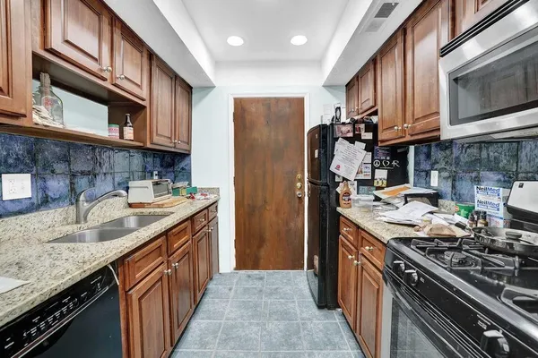 a kitchen with stainless steel appliances granite countertop a stove a sink dishwasher and a refrigerator