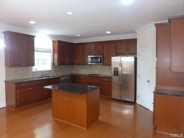 a kitchen with stainless steel appliances granite countertop a refrigerator a sink a stove a microwave and island