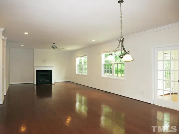 a view of an empty room with window and fire place