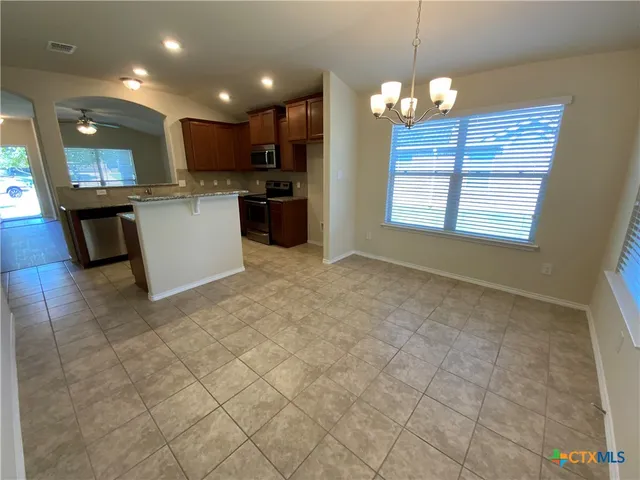 a open kitchen with kitchen island granite countertop a sink dishwasher stove top oven and cabinets