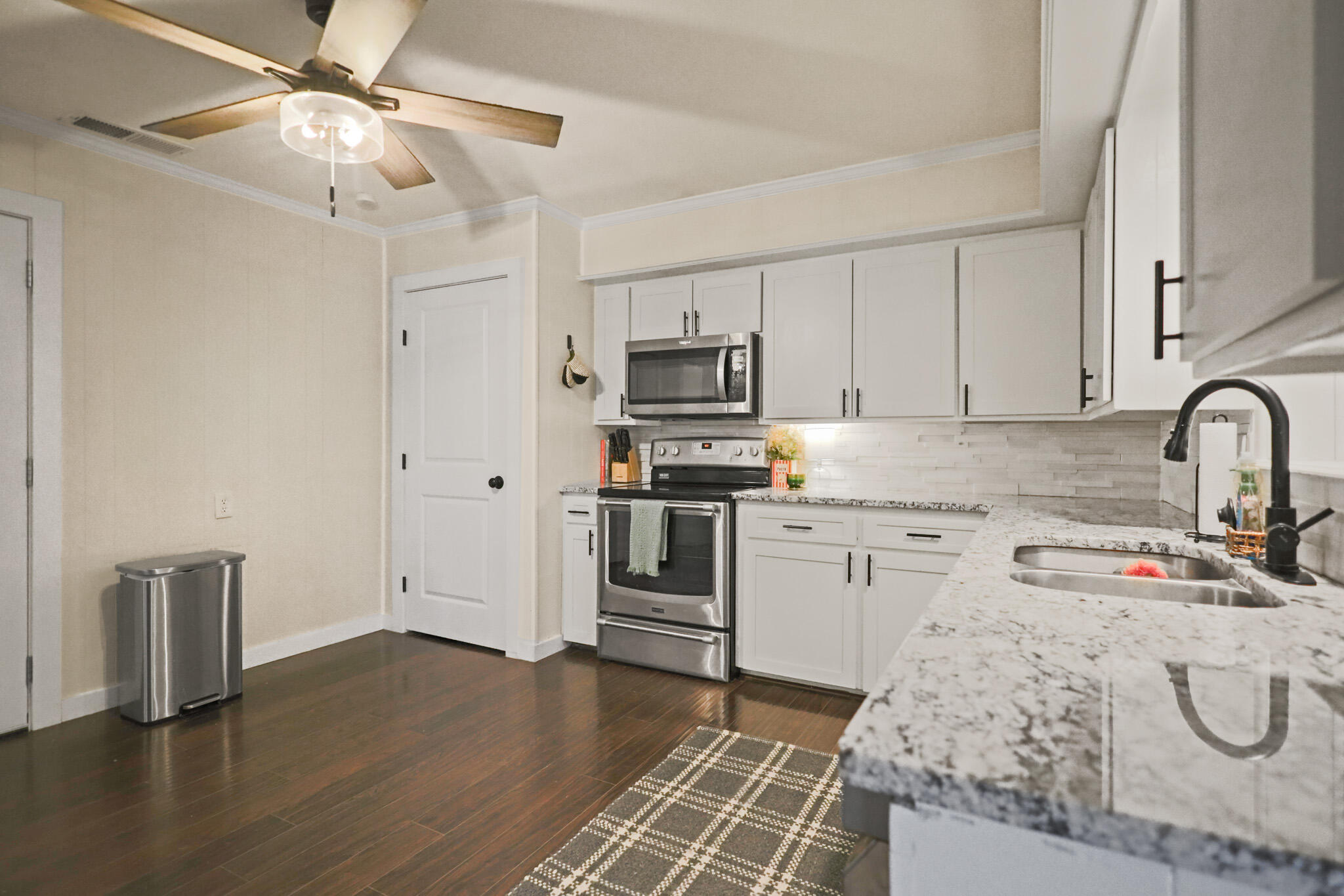 4302 42nd Street Lubbock, TX 79413 - Photo 17 of 67 a kitchen with granite countertop a stove a sink and a refrigerator