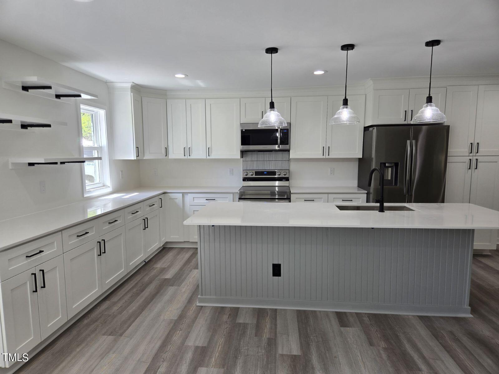 a kitchen with kitchen island white cabinets and sink