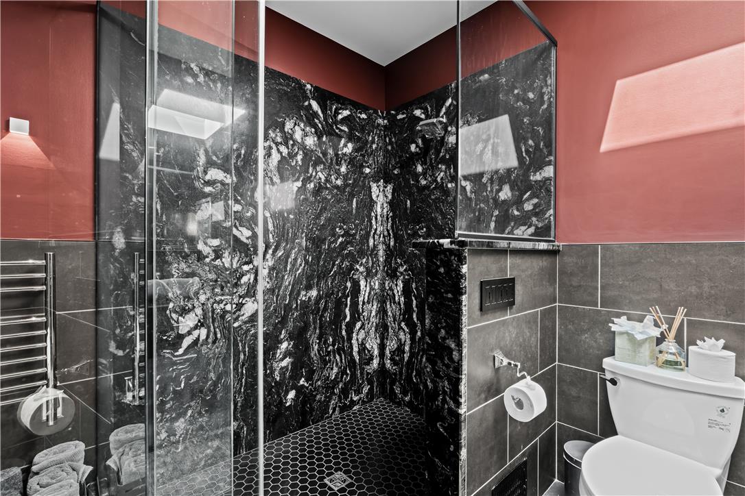 1506 Pleasant View Road Coopersburg, PA 18036 - Photo 46 of 97 A stylish bathroom showcases a glass-enclosed shower with dramatic black and white stone walls.