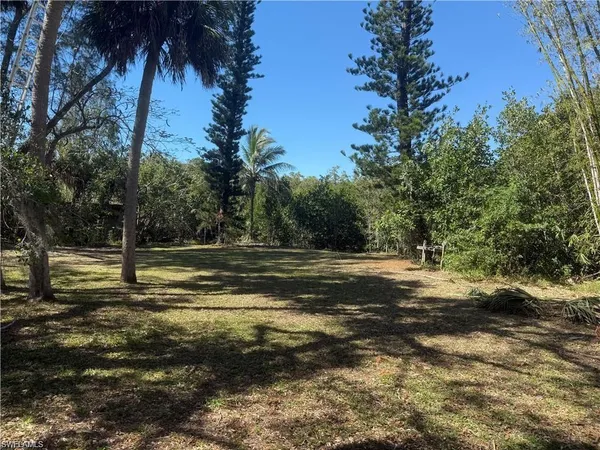 a view of a green field with wooden fence