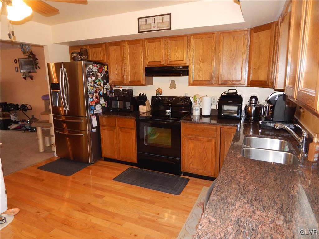 326 Chestnut Street Slatington, PA 18080 - Photo 4 of 14 a kitchen with stainless steel appliances granite countertop a refrigerator a stove and a sink with wooden floor